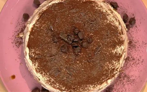 Tiramisù ricetta Benedetta: un dolce cremoso e goloso, ricoperto di cacao e scaglie di cioccolato, pronto per essere gustato.