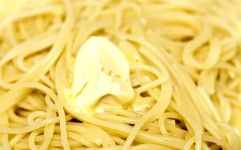 Un piatto di spaghetti fumanti, conditi con burro fuso che si scioglie lentamente. Un classico intramontabile: pasta in bianco.