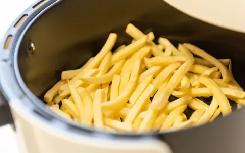 Patate dorate e croccanti pronte per essere gustate, appena uscite dalla friggitrice ad aria.