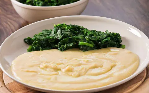 Piatto con purè di fave cremoso e spinaci saltati. Un contorno semplice e gustoso.