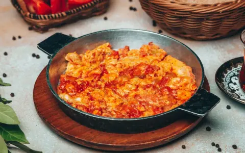 Uova strapazzate al pomodoro in padella, un piatto caldo e saporito, pronto per essere gustato.