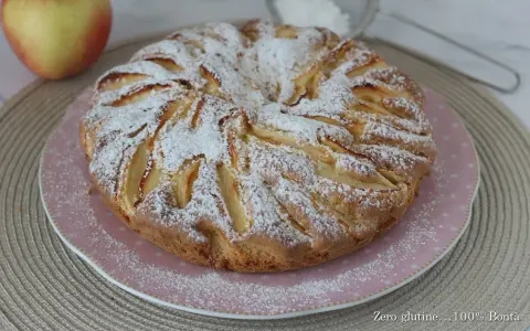 Una deliziosa torta di mele senza glutine, cosparsa di zucchero a velo, pronta per essere gustata.
