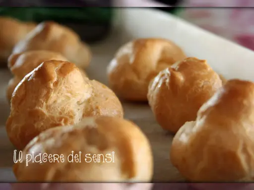 Bignè alla crema dorati e soffici, pronti per essere gustati. Un vero piacere per i sensi.