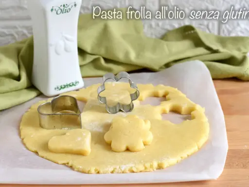 Pasta frolla all'olio senza glutine pronta per essere trasformata in biscotti con formine a cuore e fiore.