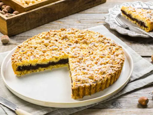 Sbriciolata alla Nutella con un ripieno goloso e una copertura croccante di nocciole. Perfetta per ogni occasione.