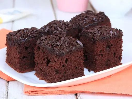 Fette di torta al cioccolato, soffici e ricoperte di scaglie di cioccolato fondente, pronte per essere gustate.