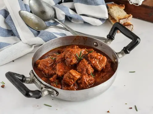 Un invitante spezzatino di vitello in umido, pronto per essere gustato. La ricetta perfetta per un pranzo domenicale.