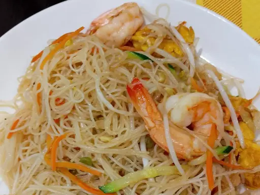 Spaghetti di riso con gamberi, carote, zucchine e germogli di soia. Un piatto leggero e gustoso.
