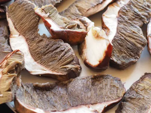 Fette di funghi porcini pronti per essere cucinati in padella, con le lamelle ben visibili.