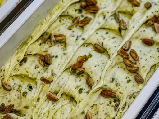 Gelato cremoso al pesto di pistacchio, guarnito con pistacchi interi tostati. Un'esplosione di gusto e colore.
