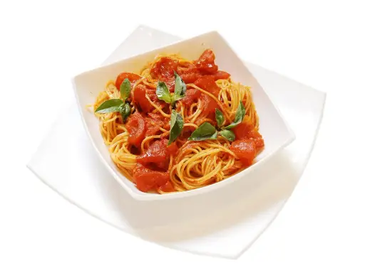 Un invitante piatto di spaghetti al pomodoro fresco, guarnito con foglie di basilico verde brillante.
