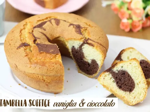 Ciambellone soffice alla vaniglia e cioccolato, con una fetta tagliata che mostra l'interno marmorizzato.