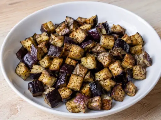 Melanzane a cubetti, cotte in friggitrice ad aria, dorate e saporite, pronte per essere gustate.