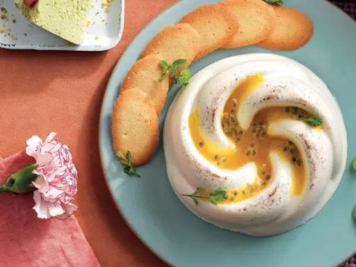 Deliziosa crema al latte con frutto della passione e biscotti, guarnita con menta. Un dolce invitante.