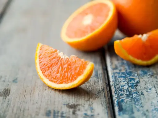 Arance fresche tagliate a spicchi su un tavolo di legno. Quante arance si possono mangiare al giorno? Dipende dal tuo fabbisogno di vitamina C.