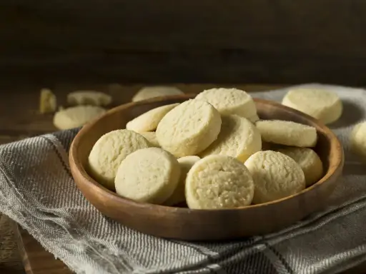 Una ciotola di legno piena di deliziosi biscotti senza uova, perfetti per una pausa dolce.