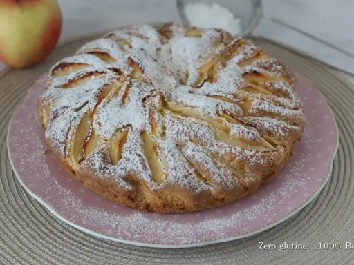 Una deliziosa torta di mele senza glutine, cosparsa di zucchero a velo, pronta per essere gustata.