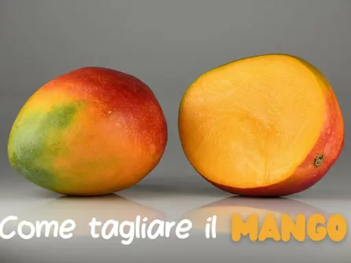 Un mango intero e uno tagliato a metà, mostrando la polpa succosa. Impara come si mangia il mango per gustarlo al meglio.