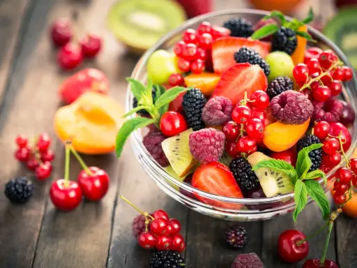 Ciotola di frutta fresca con fragole, lamponi, ribes, more e kiwi, un'ottima scelta di frutta con meno zuccheri.