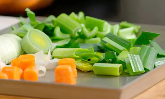 Carote, porri e sedano tagliati a pezzi, ingredienti perfetti per imparare come fare brodo vegetale.