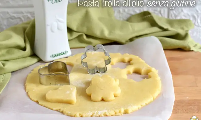 Pasta frolla all'olio senza glutine pronta per essere trasformata in biscotti con formine a cuore e fiore.