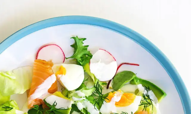Insalata fresca con salmone, uova sode, avocado e ravanelli. Un piatto gustoso e leggero, ideale per chi cerca cibi senza carboidrati.