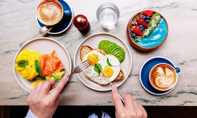 Colazione sana: uova, salmone, avocado, smoothie bowl e caffè. Ottimi esempi di colazione a basso indice glicemico per iniziare la giornata con energia.