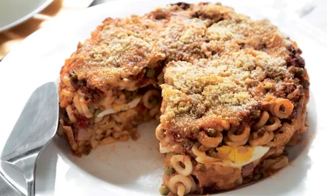 Un invitante anelletti al forno, con strati di pasta, ragù, piselli e uova sode, dorato e croccante in superficie.
