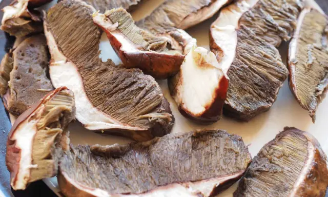 Fette di funghi porcini pronti per essere cucinati in padella, con le lamelle ben visibili.