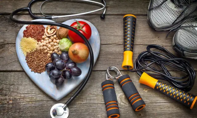 Stetoscopio, cuore di legno con 20 alimenti che alzano la pressione, attrezzi per fitness e scarpe da corsa.