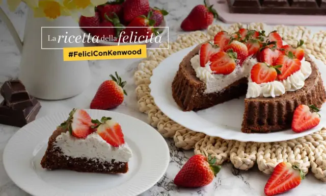 Una crostata morbida al cioccolato, guarnita con panna e fragole fresche, è la ricetta della felicità.