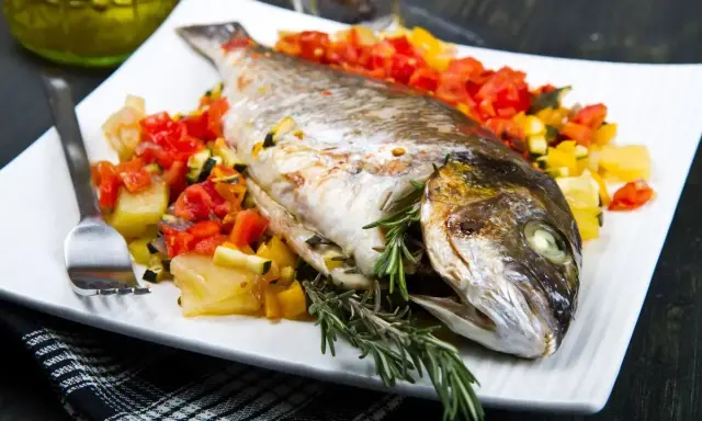 Orata intera cotta in friggitrice ad aria, servita con verdure miste e rosmarino.