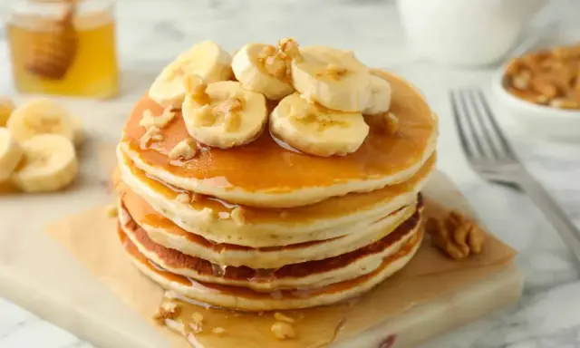 Pancakes leggeri con banane e noci, una deliziosa ricetta pancake light, guarniti con sciroppo d'acero e miele.