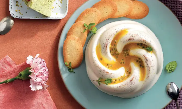 Deliziosa crema al latte con frutto della passione e biscotti, guarnita con menta. Un dolce invitante.
