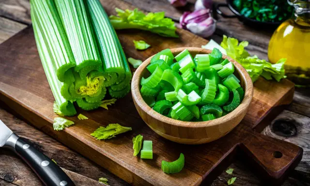 Sedano fresco, tagliato a pezzi in una ciotola, pronto per essere gustato. Verdure che non gonfiano la pancia, perfette per una dieta leggera e salutare.