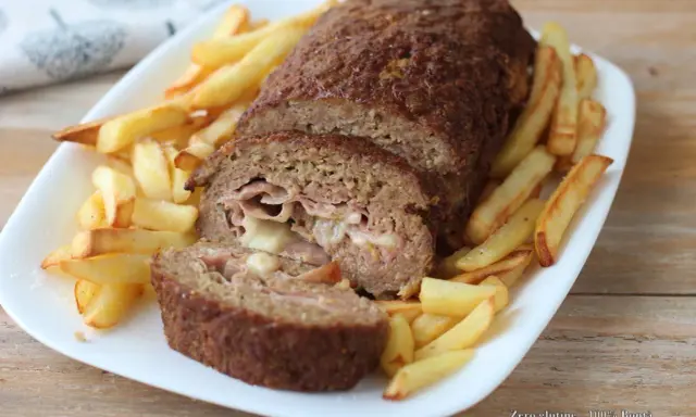 Polpettone ripieno di prosciutto e formaggio, cotto in friggitrice ad aria, servito con patatine fritte croccanti.