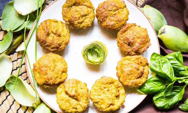 Muffin dorati, perfetti per una colazione proteica salata. Circondati da carciofi e basilico fresco, invitano a un pasto nutriente.