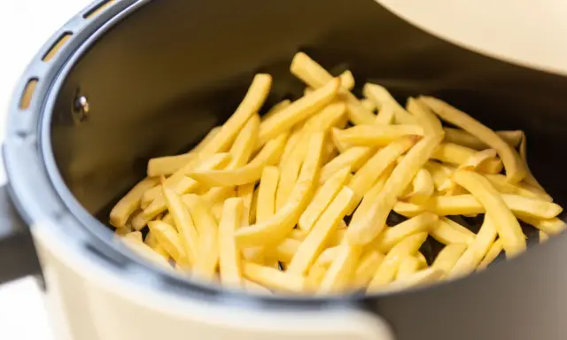 Patate dorate e croccanti pronte per essere gustate, appena uscite dalla friggitrice ad aria.