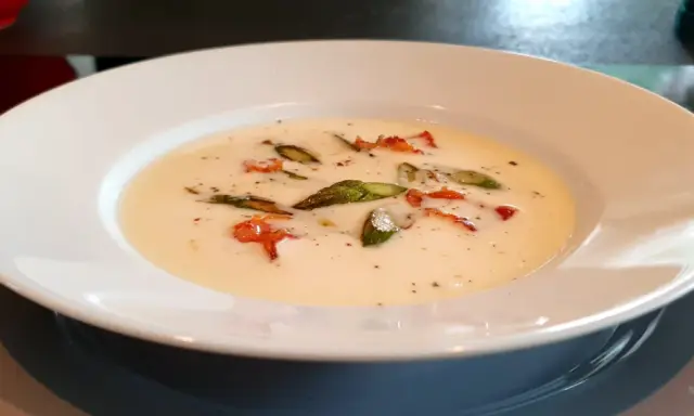 Una cremosa fonduta di pecorino con asparagi e pancetta croccante, un piatto che scalda il cuore.