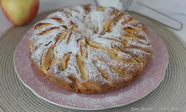 Una deliziosa torta di mele senza glutine, cosparsa di zucchero a velo, pronta per essere gustata.