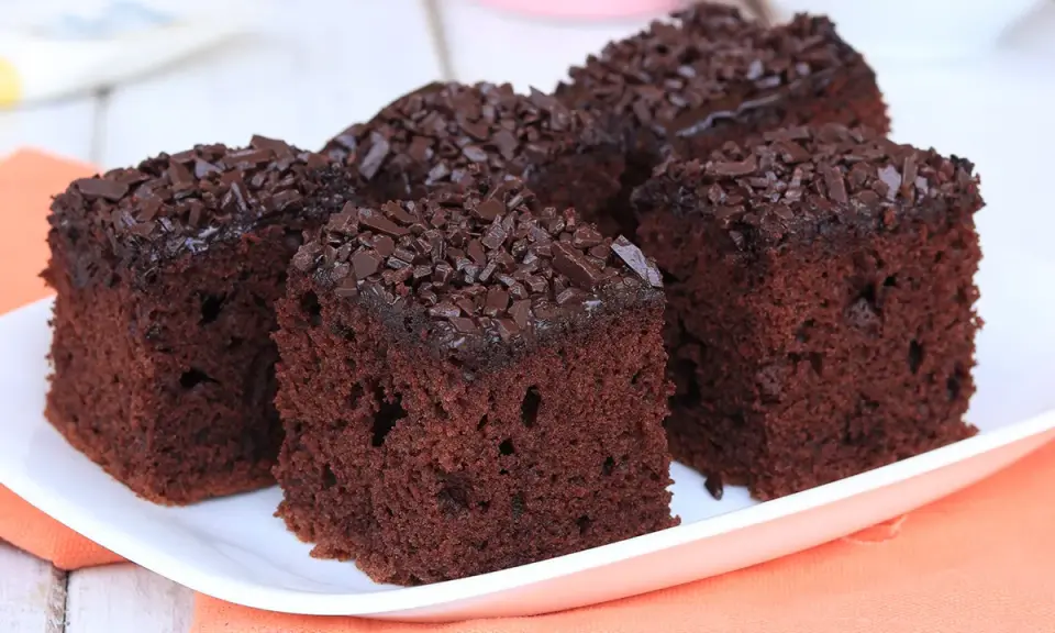 Fette di torta al cioccolato, soffici e ricoperte di scaglie di cioccolato fondente, pronte per essere gustate.