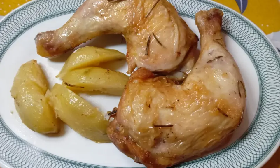 Cosce di pollo in friggitrice ad aria, dorate e succulente, servite con patate arrosto. Un piatto semplice e gustoso.