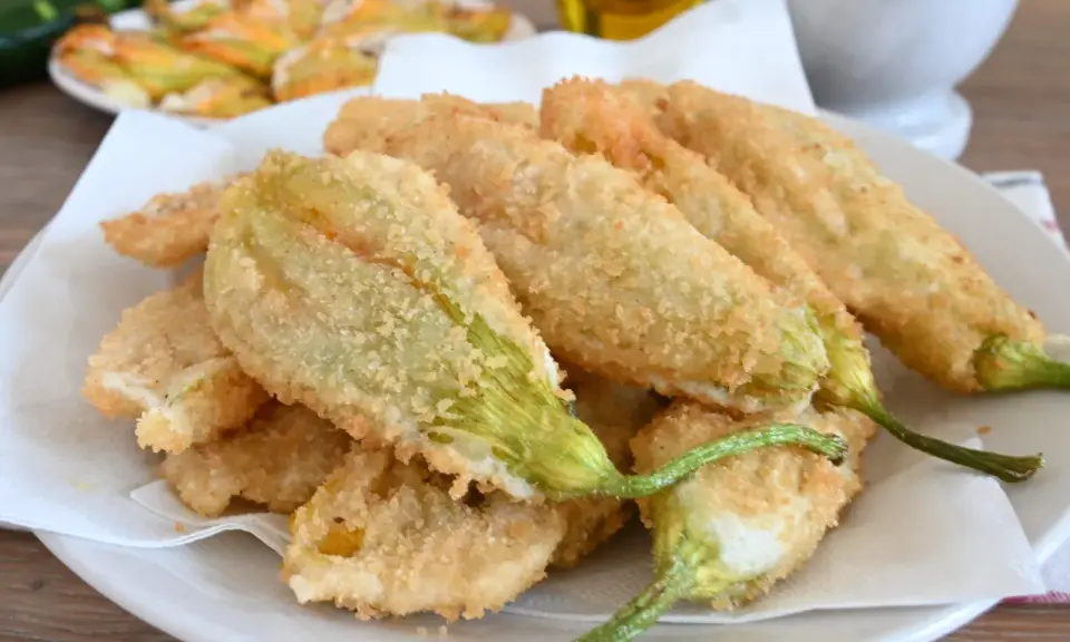 Fiori di zucca fritti, croccanti e dorati, preparati con una leggera pastella per fiori di zucca.
