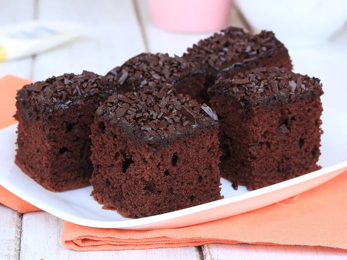 Fette di torta al cioccolato, soffici e ricoperte di scaglie di cioccolato fondente, pronte per essere gustate.