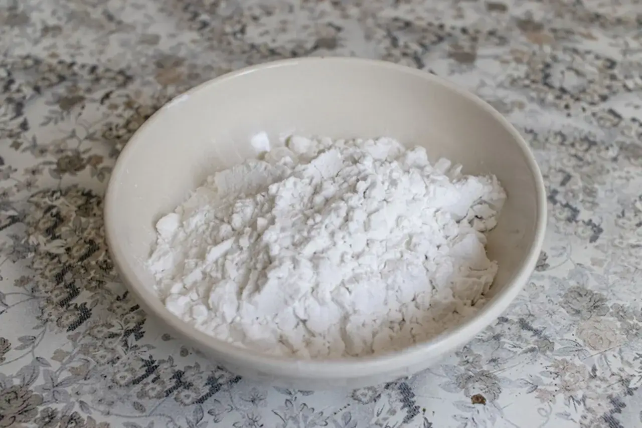 Una ciotola piena di frumina, una polvere bianca e soffice, pronta per addensare salse o dolci.