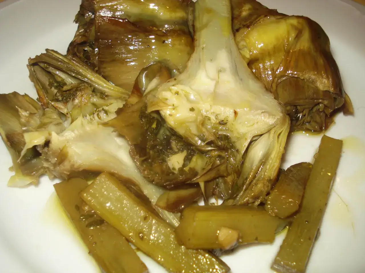 Carciofi alla romana teneri e succulenti, cotti in padella con erbe aromatiche e conditi con olio d'oliva.