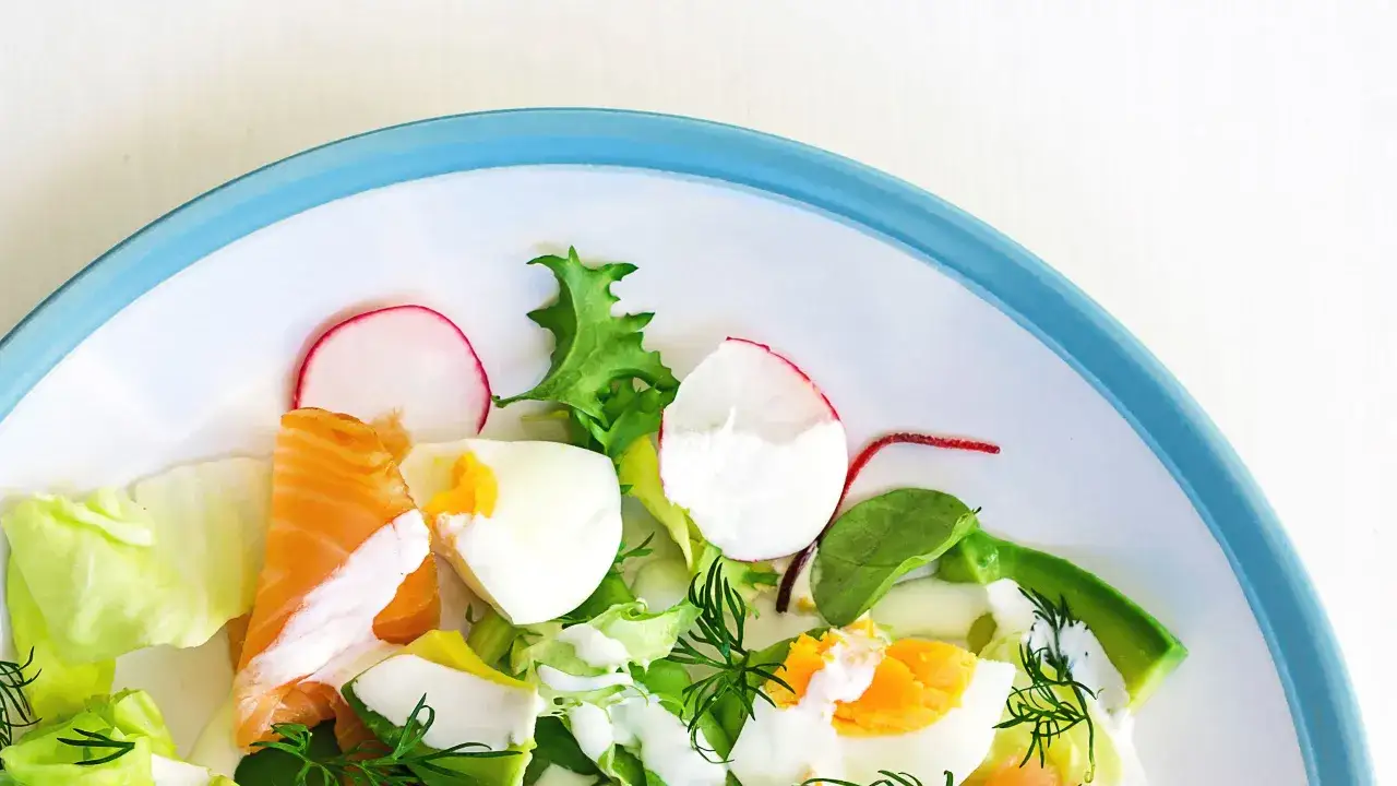 Insalata fresca con salmone, uova sode, avocado e ravanelli. Un piatto gustoso e leggero, ideale per chi cerca cibi senza carboidrati.