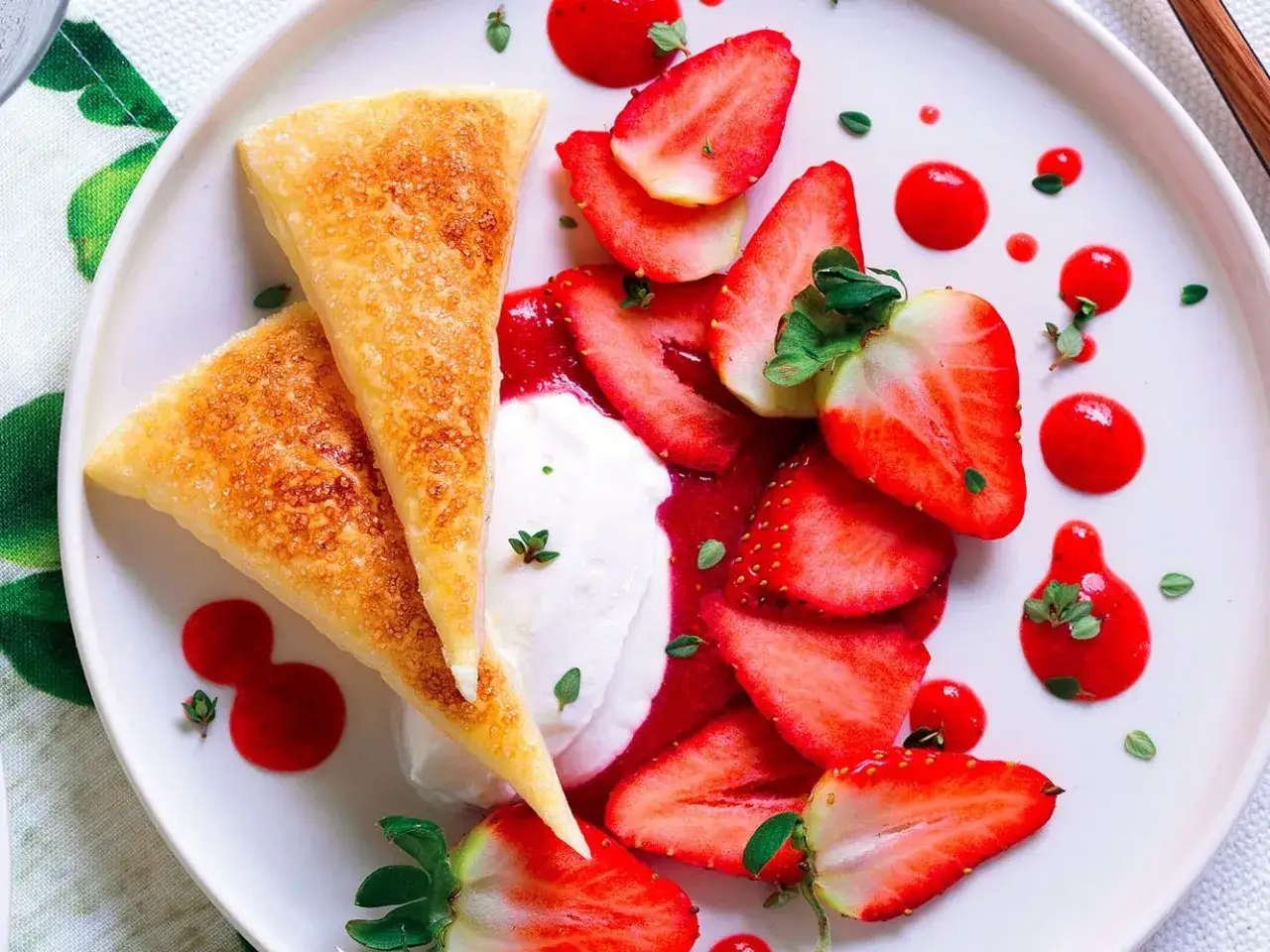 Triangoli dorati su un letto di crema, fragole fresche e salsa rossa, un delizioso tiramis&ugrave; alle fragole.