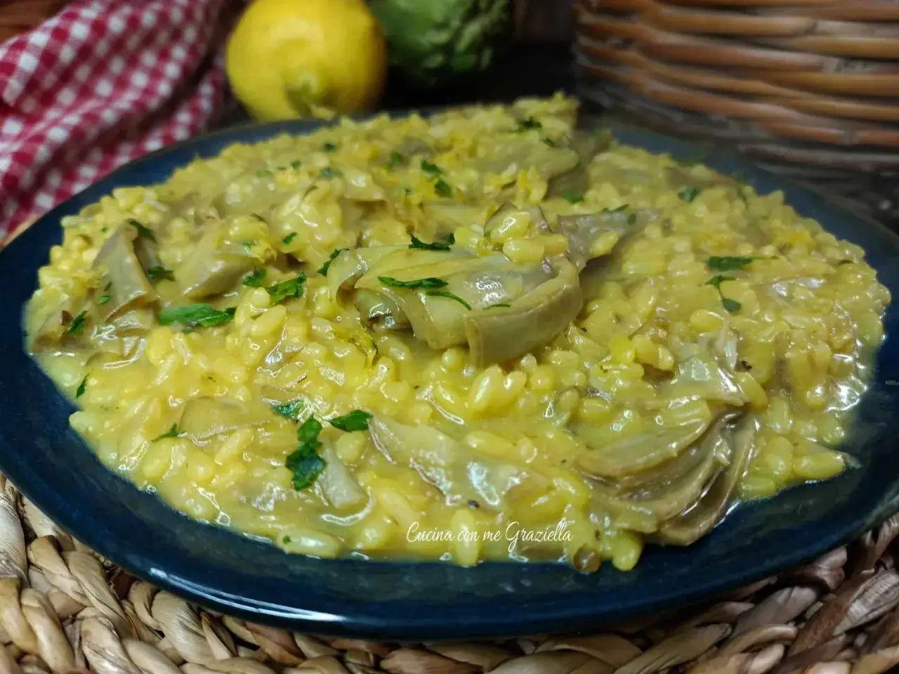 Un cremoso risotto con carciofi freschi, guarnito con prezzemolo e scorza di limone.