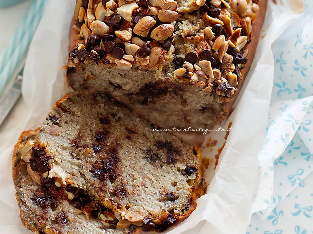 Delizioso banana bread light con gocce di cioccolato e noci, una fetta invitante.